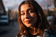 Portrait of a smiling young woman outdoors during golden hour.